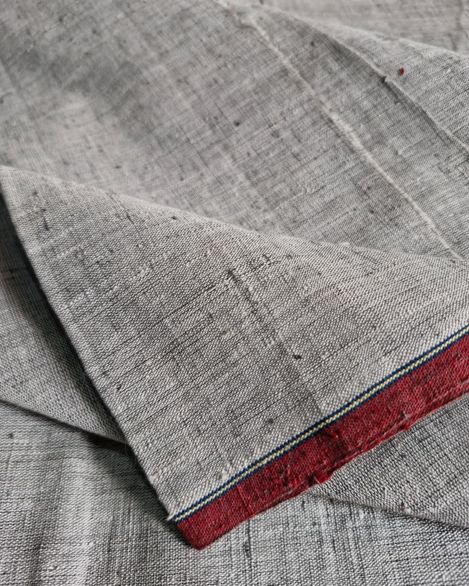 Close-up of gray fabric with a red border