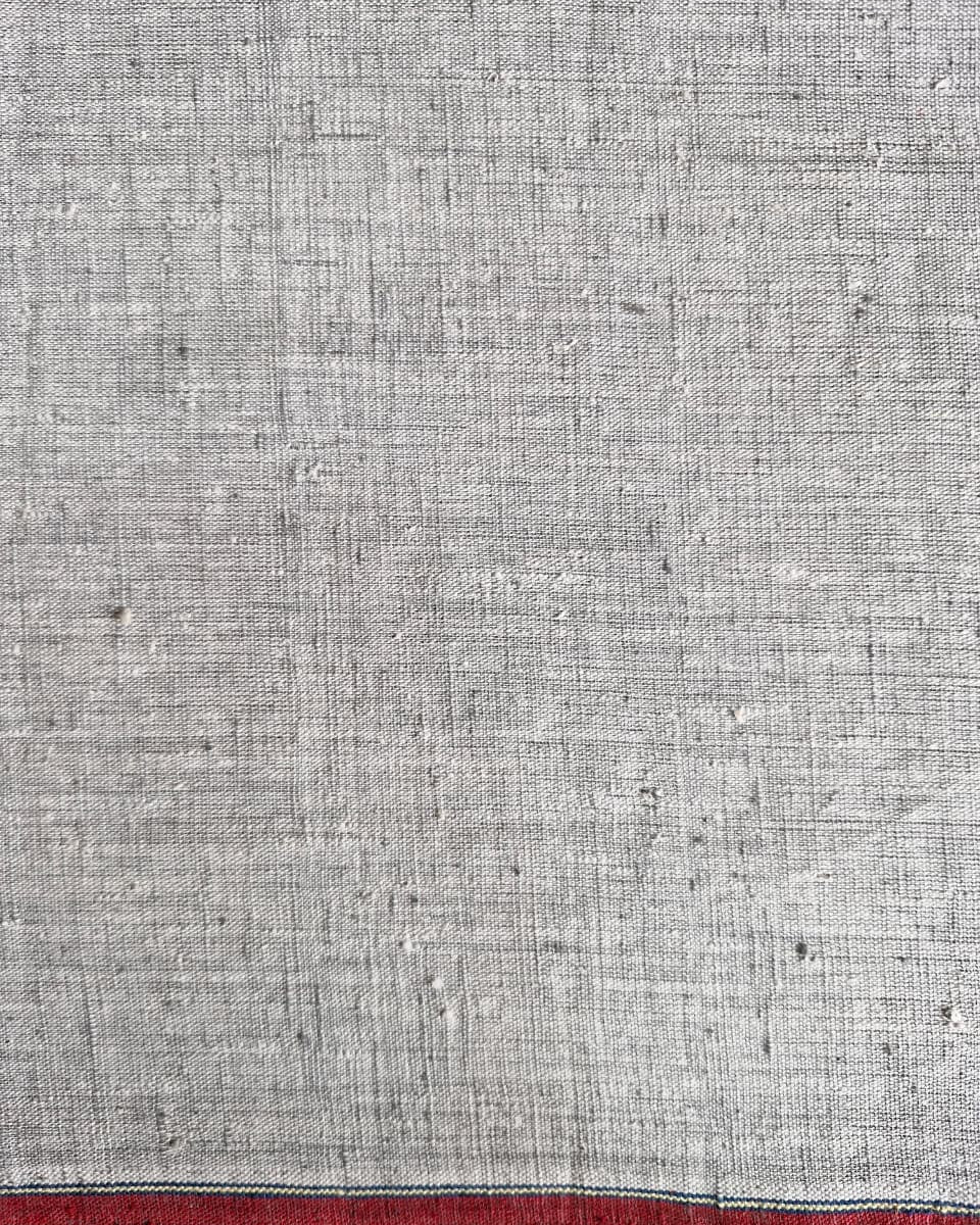 Textured gray fabric with a red stripe at the bottom