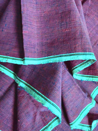 Close-up of maroon fabric with green border