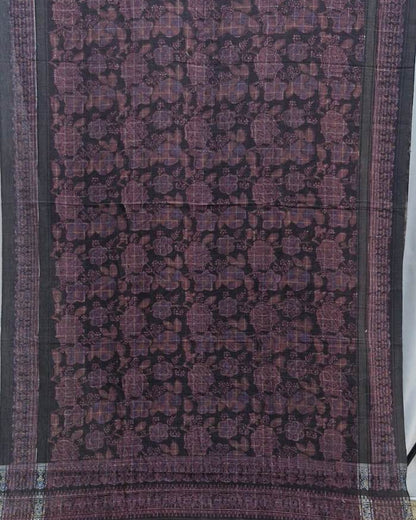 A dark purple and black patterned fabric, likely a saree or scarf, featuring a detailed floral and geometric motif with a striped border.