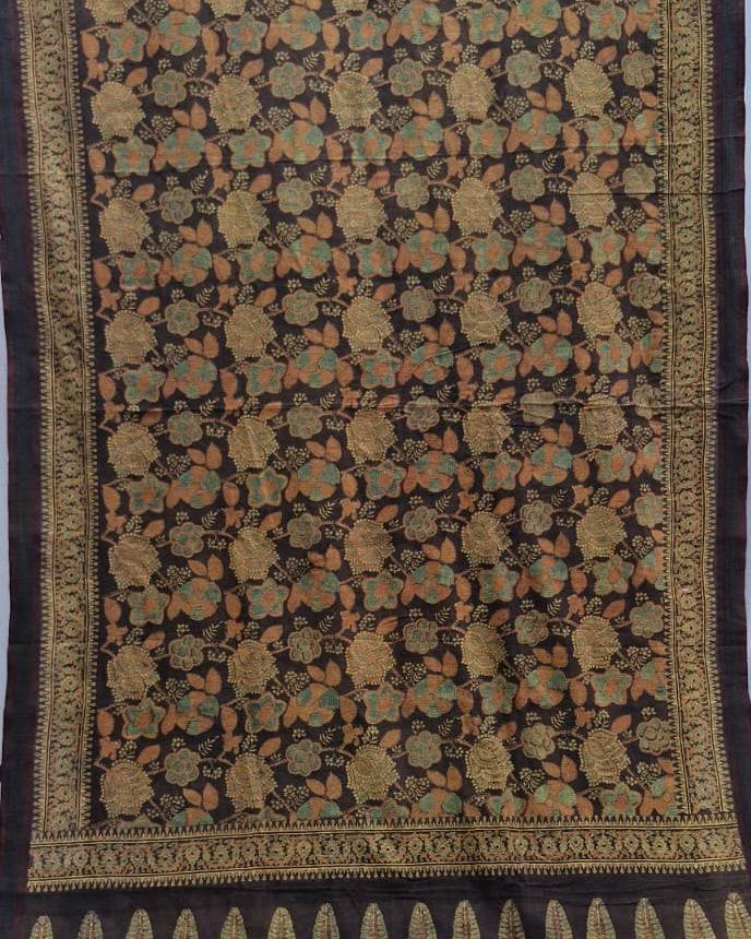 A dark brown or black silk saree with intricate gold, beige, and orange floral motifs and a detailed border.