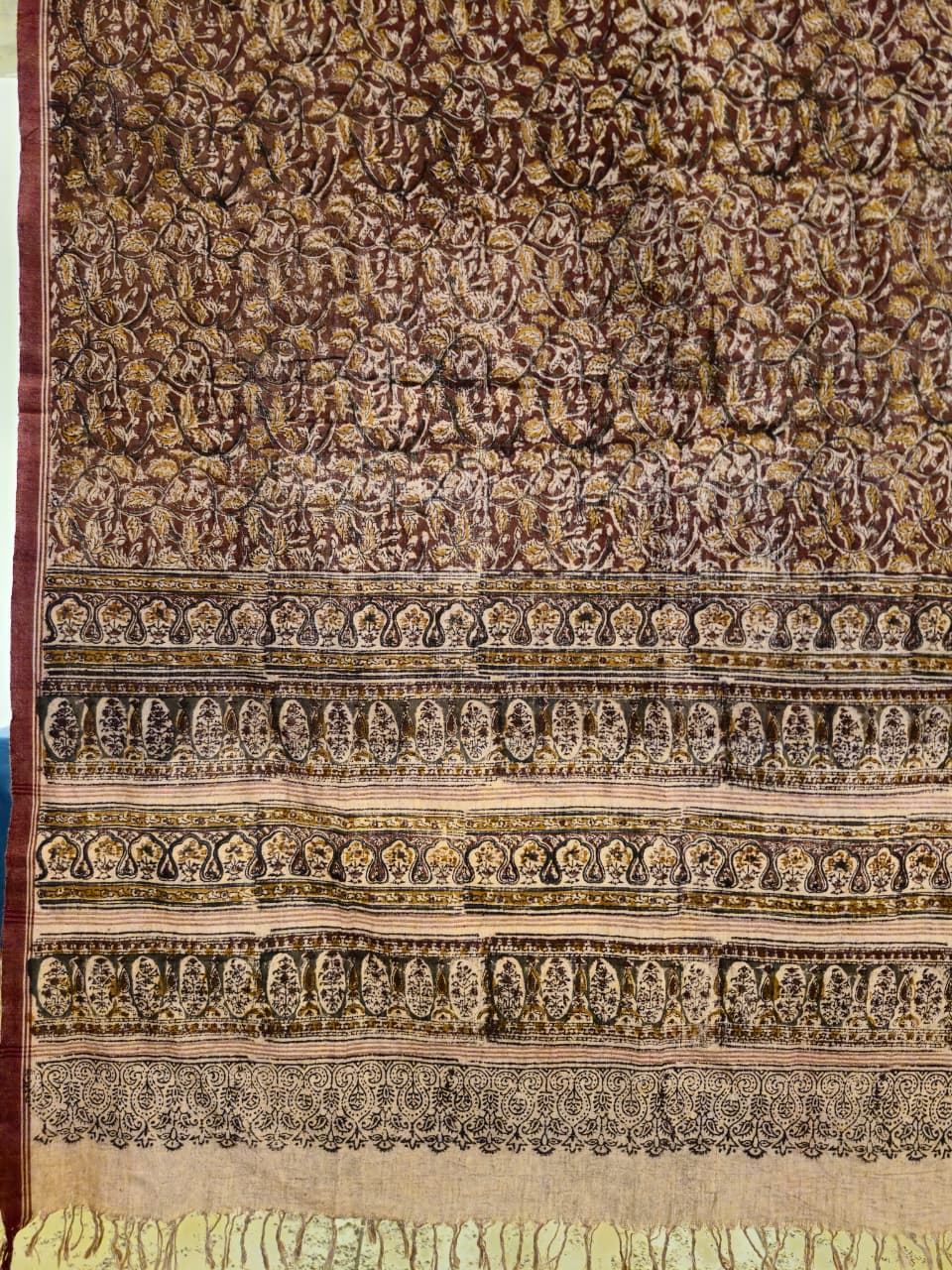 Textile with intricate patterns and designs on a brown background