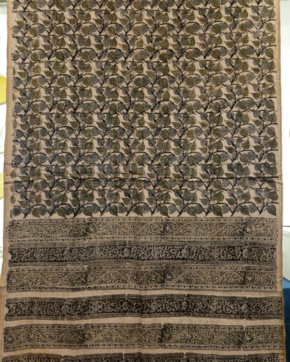 A rectangular handloom fabric or sari with an intricate floral block print pattern in olive green and black on a beige background, featuring a wide decorative border at the bottom.