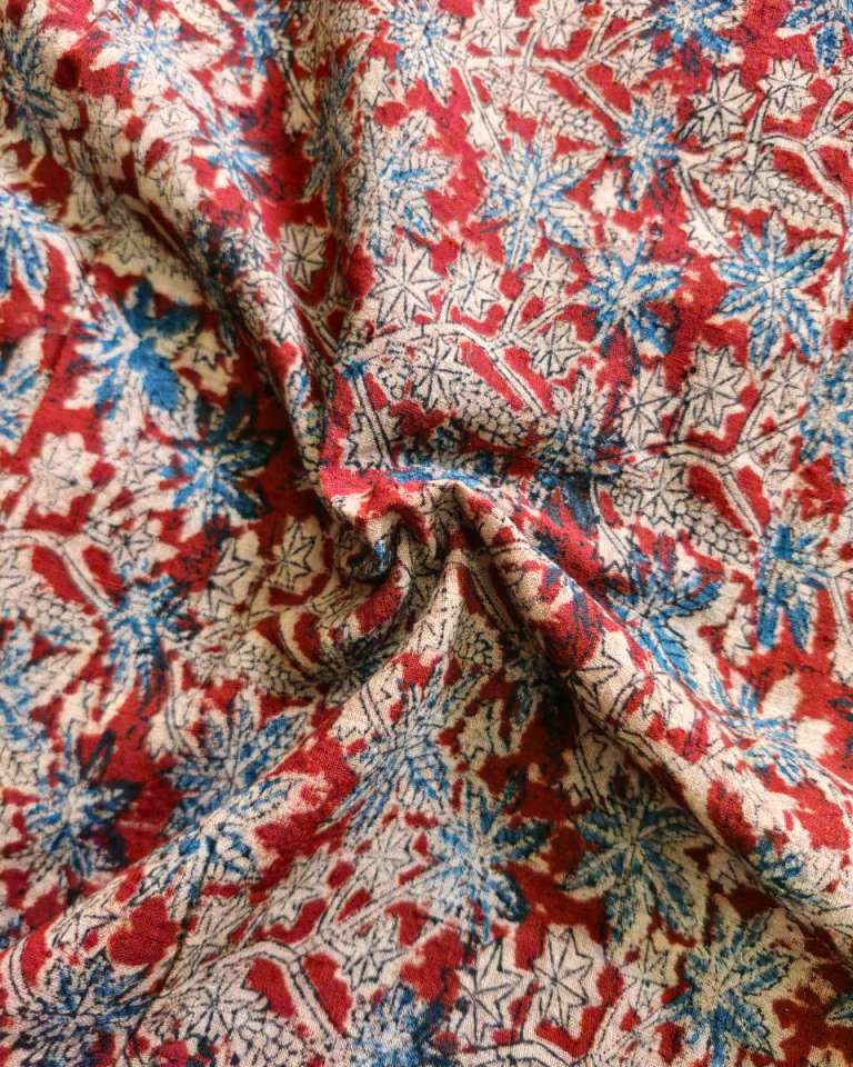 Close-up of floral patterned fabric with red, blue, and beige colors.