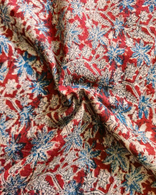 Close-up of floral patterned fabric with red, blue, and beige colors.