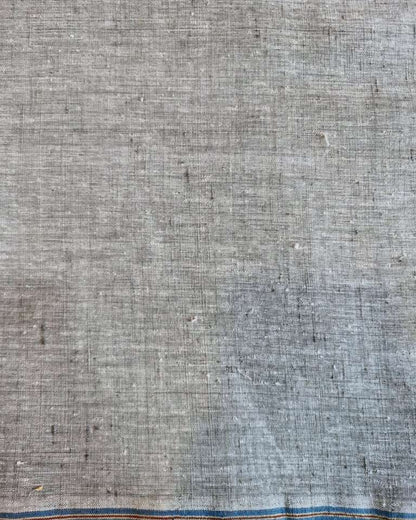 A close-up of a textured gray fabric with a blue and orange stitched border along the bottom edge.