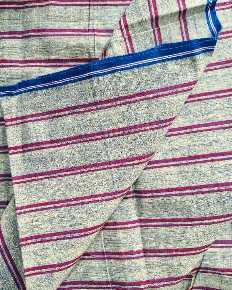 A close-up of a striped fabric, likely a sari, featuring a heathered light gray base with horizontal magenta-pink stripes and a prominent royal blue border.