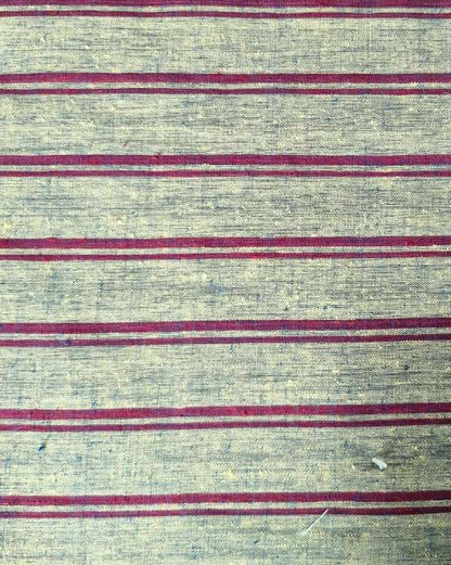 A close-up of a woven textile with a textured beige base and horizontal stripes in muted red and gray.